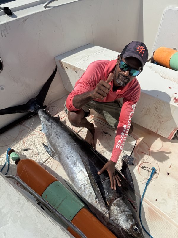 Pêcheur brandissant un marlin pêché au large de la Martinique