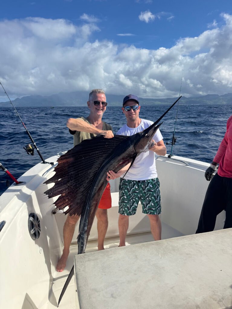 Deux pêcheurs tenant un voilier capturé lors d'une sortie pêche au gros en Martinique